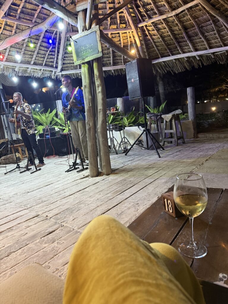 Moi seule au restau, avec un verre de vin blanc, regardant un groupe de musique